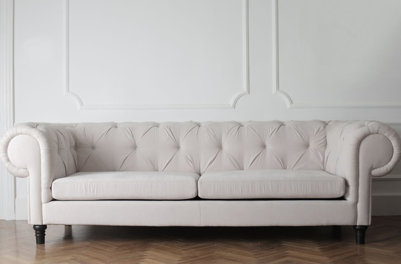 about-img-01 A refined white sofa set in a modern minimalist room with wood flooring.